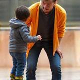 Instructor helping a beginner skateboarder stand on a board